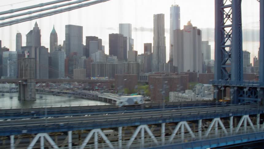 Cars trucks and cabs travel across the river to and from the city on a multi level bridge