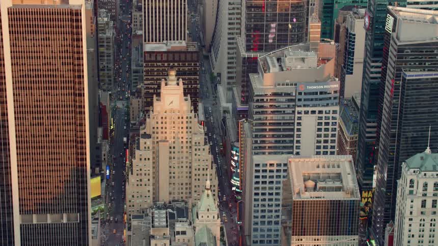 Traffic moves on roads between tall urban skyscrapers