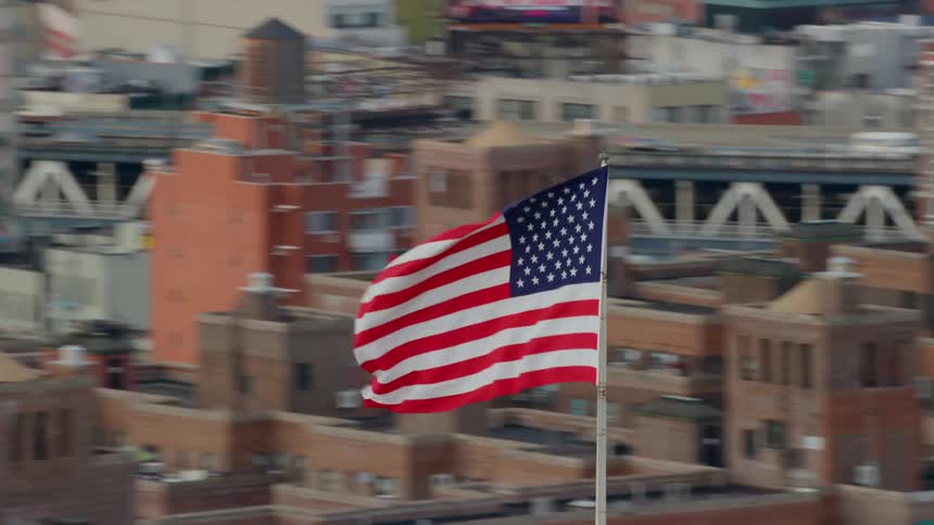 The flag blows in the wind at the top of the building
