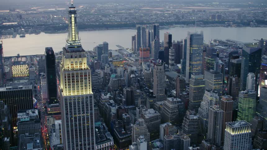 Empire state building in front of the hudson river on new york city at sunset