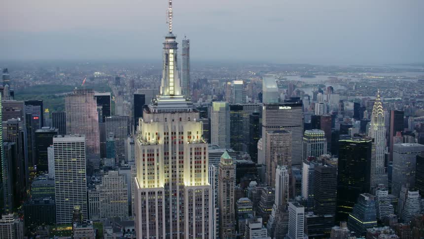 A skyscraper with buildings and the sky in the background