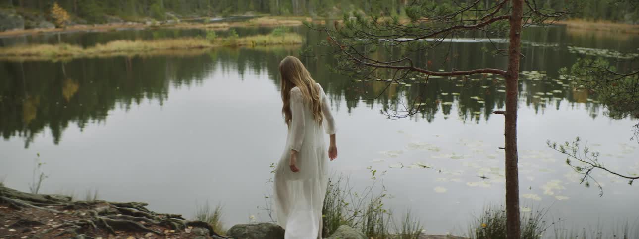 A woman walks close to the lake