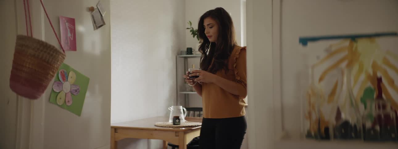 A woman is drinking from a glass indoors