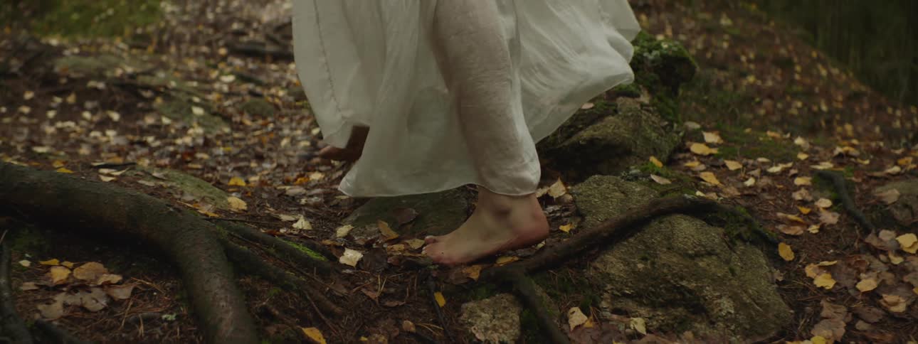 A woman is walking through a nature area