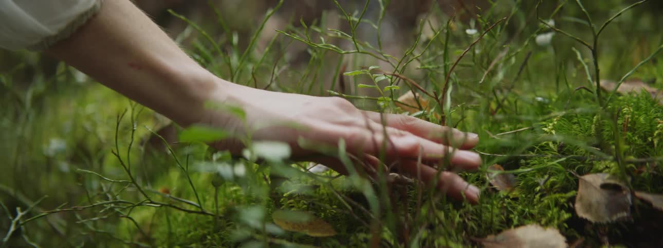 A woman drags her hand along the ground