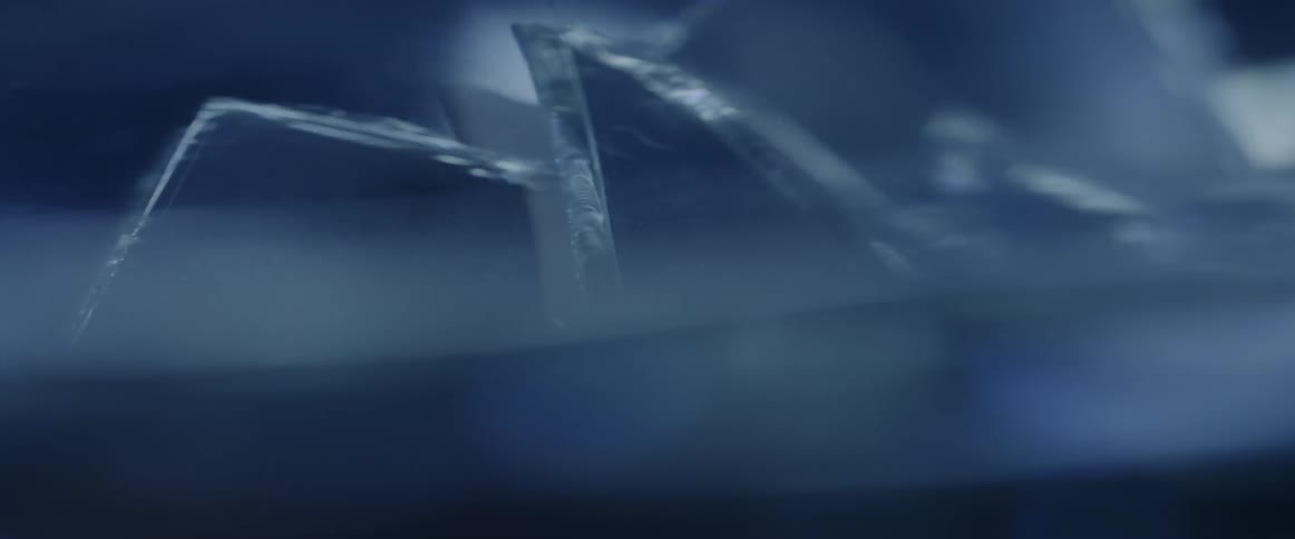 The jagged edges of thick clear glass with a bluish tint