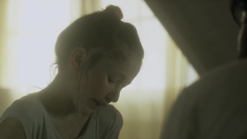 A girl is talking with someone as she looks down