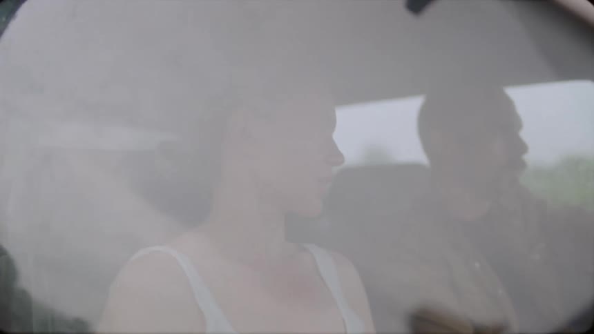 A man and woman are sitting in a car talking