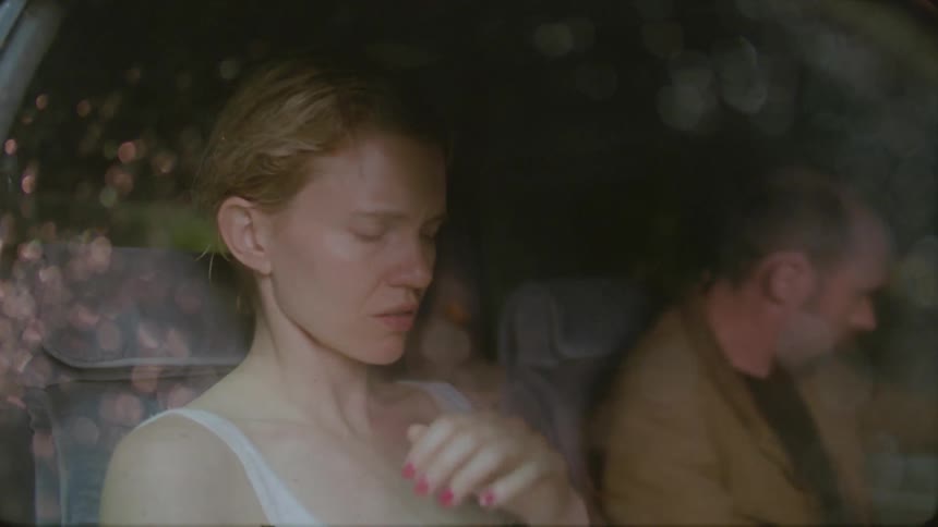 A man and woman are speaking in a car before the man gets out