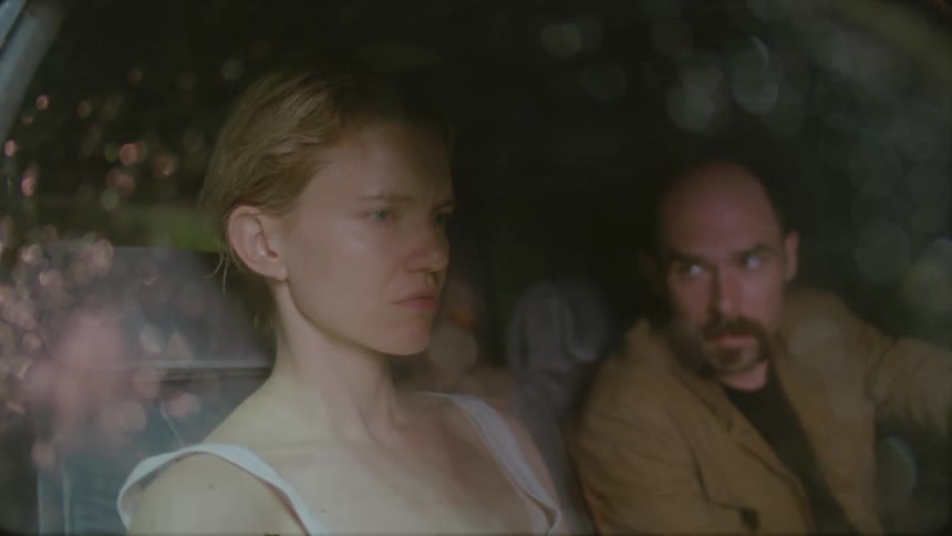 Man talking sternly to an unhappy woman in a car