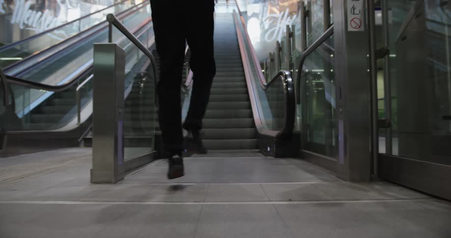 A person running and skipping towards an escalator