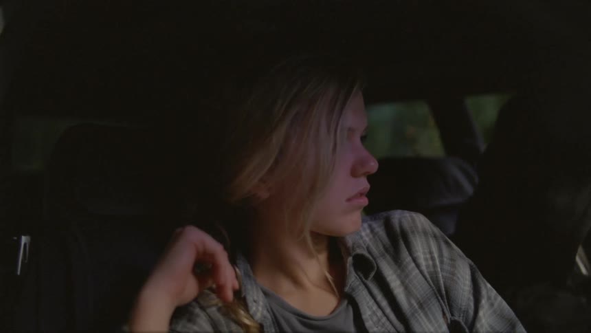 A man wakes up a woman who is sleeping in a car at night