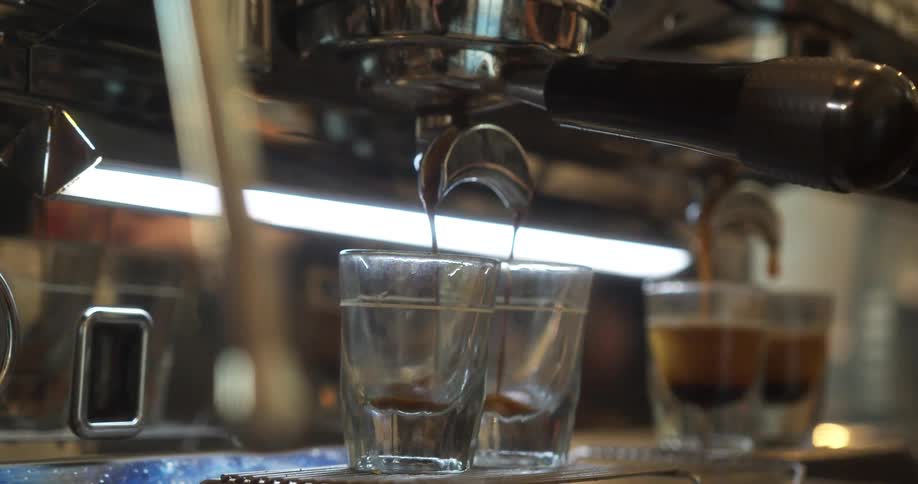 Shot glasses fill up with espresso at a coffee shop