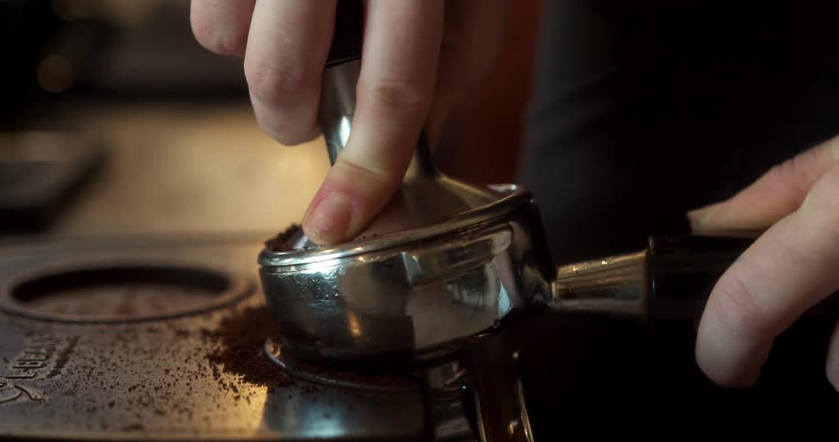 A server is preparing coffee in a cafe