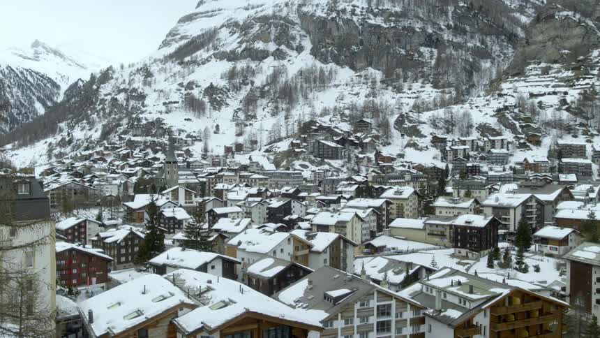 A village sits in a mountain valley during the winter