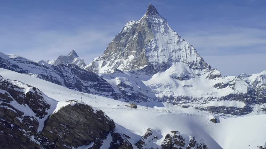 The tall snow covered pointed mountain Matterhorn looming over a ski slope