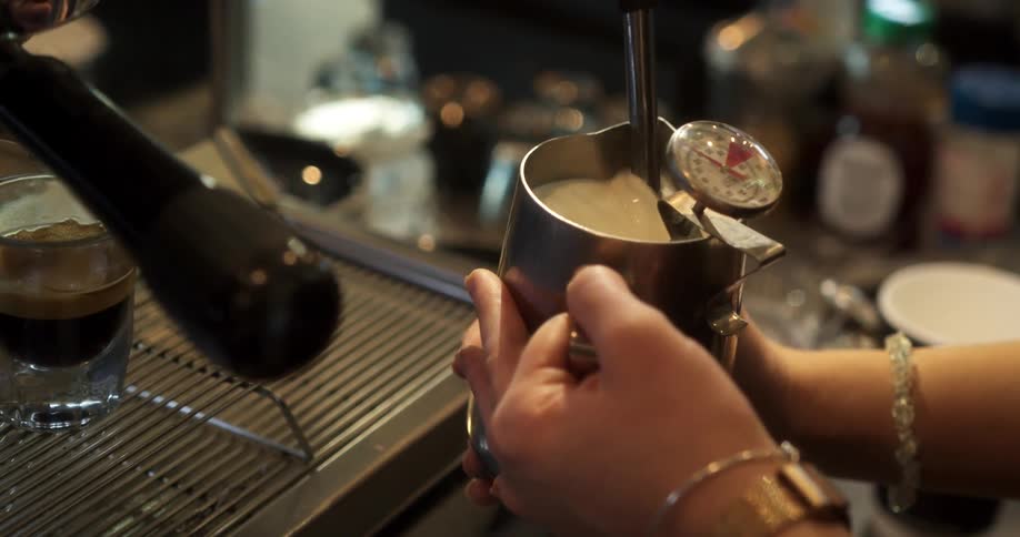 A woman makes a drink at a coffee shop