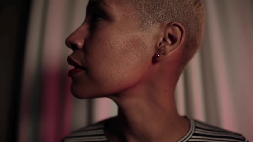 A black woman looks to her side and blinks