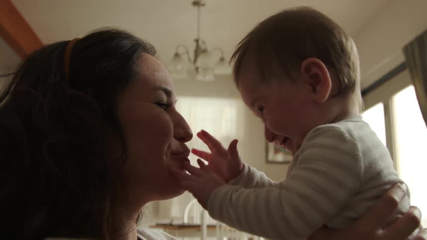 A mother and her baby play while sitting in their home