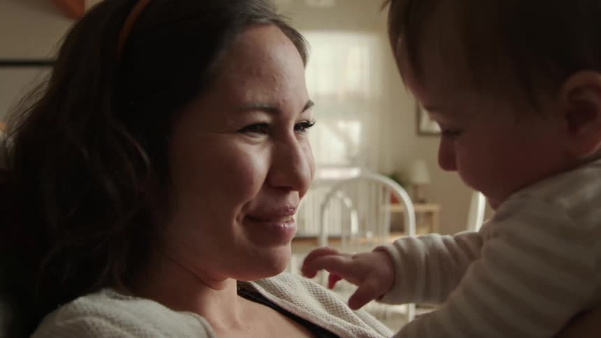 A mother is playing with her child indoors