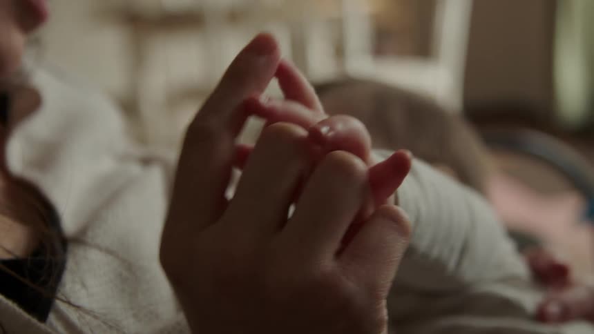 A mother and her child rub their fingers together