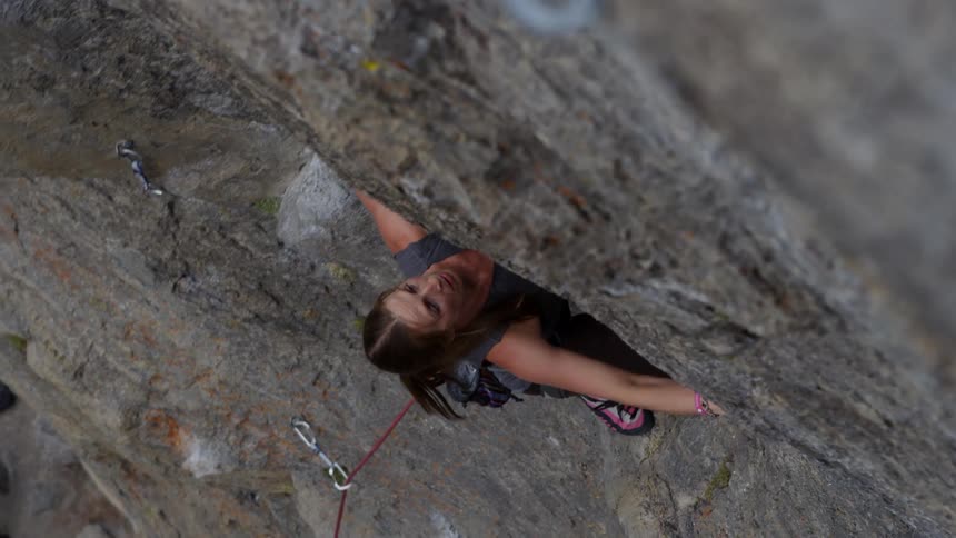 A woman on the side of a cliff rock climbing