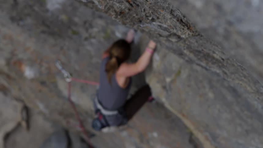 A woman is climbing up a mountain outdoors