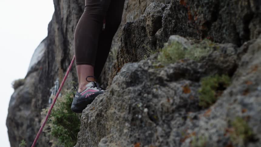 A woman concentrates as she rock climbs