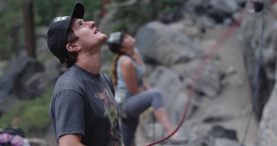 A man and woman are rock climbing outdoors