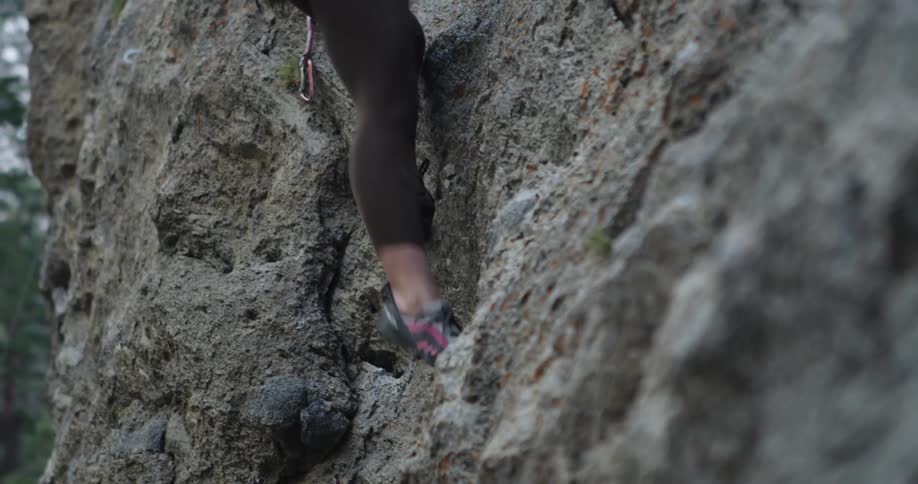 Woman rock climbing on steep cliff face