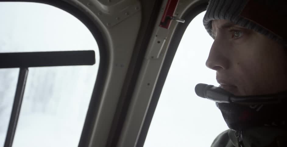 The man looks out of the helicopter window