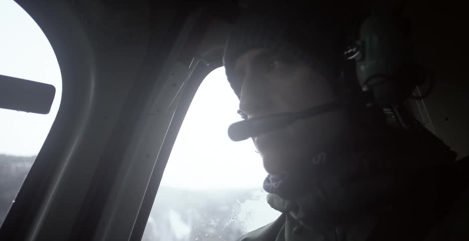 A man with a headset flying an aircraft