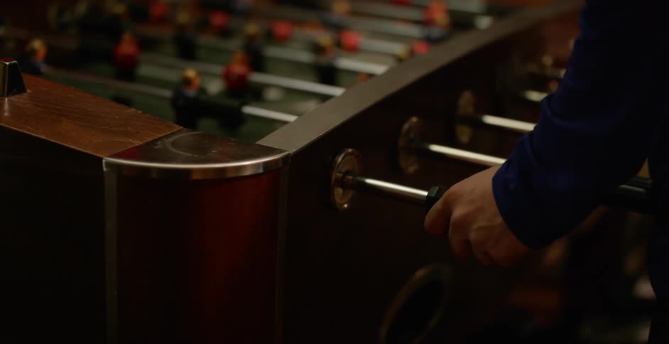 People are playing a game of foosball