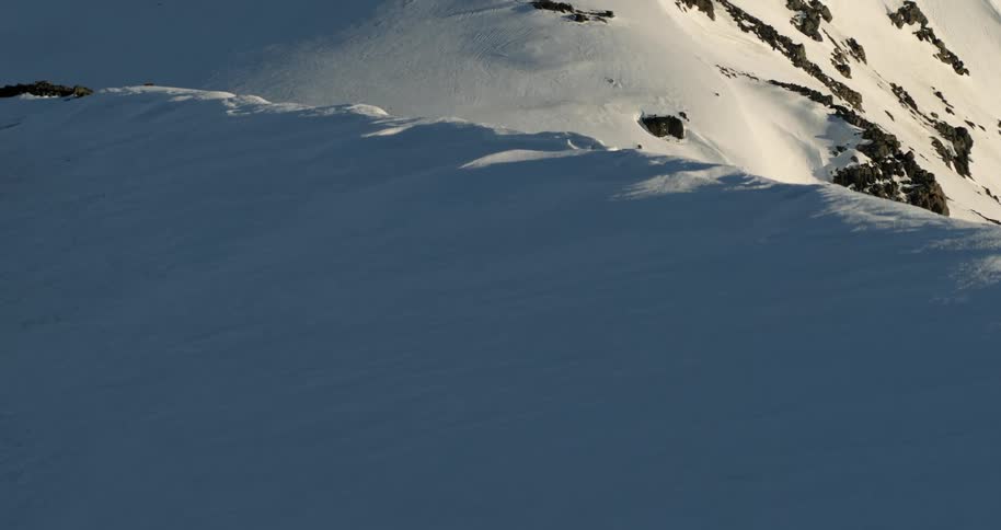 Aerial as two skiers are revealed on a huge mountain ridge