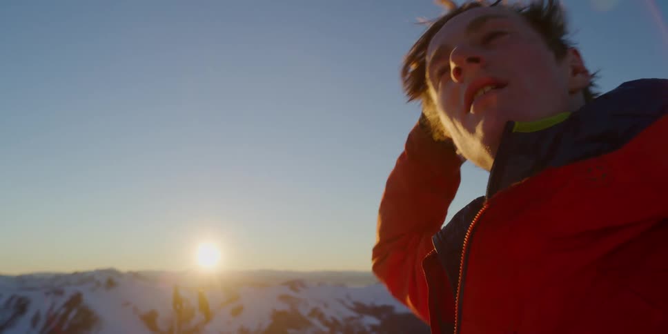 A man outside in the snow rubs his hands through his hair and shakes his head