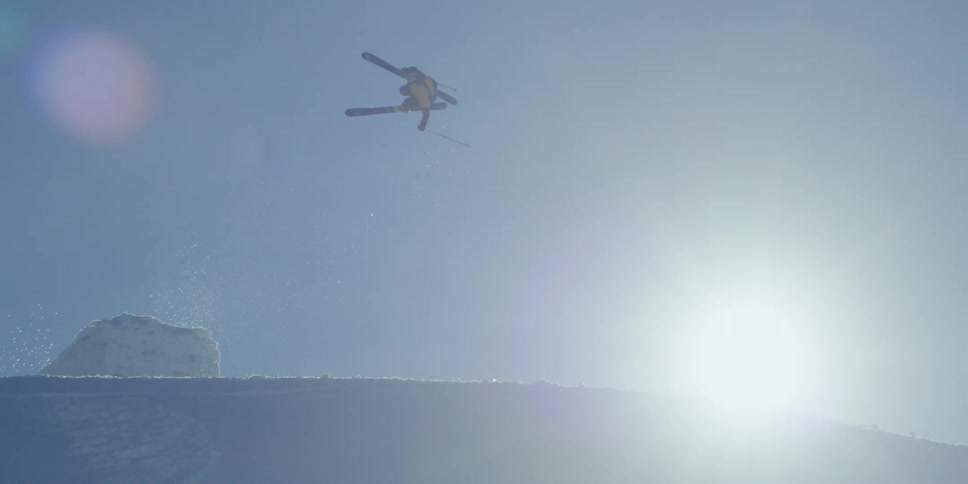 A skier does a huge jump through the sun