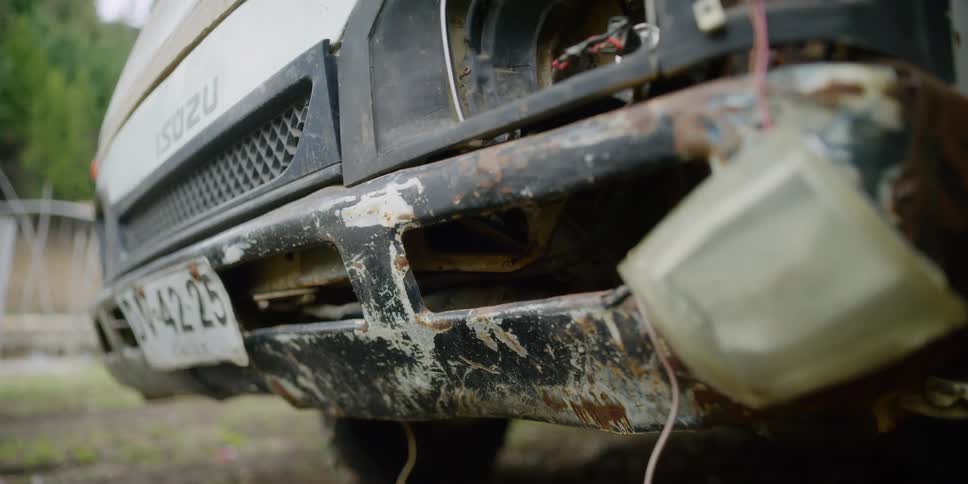 Car with damaged and rusted bumper on the road