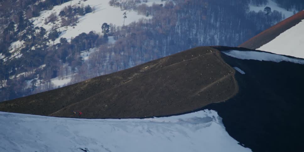 A pair of hikers walking along the top of a mountain ridge