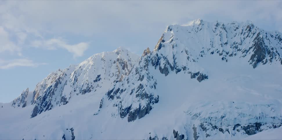 The tops of snow covered mountains at sunset