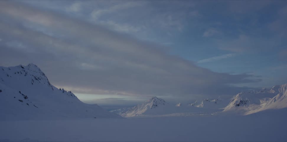 A snow covered mountain range at sunrise timelapse