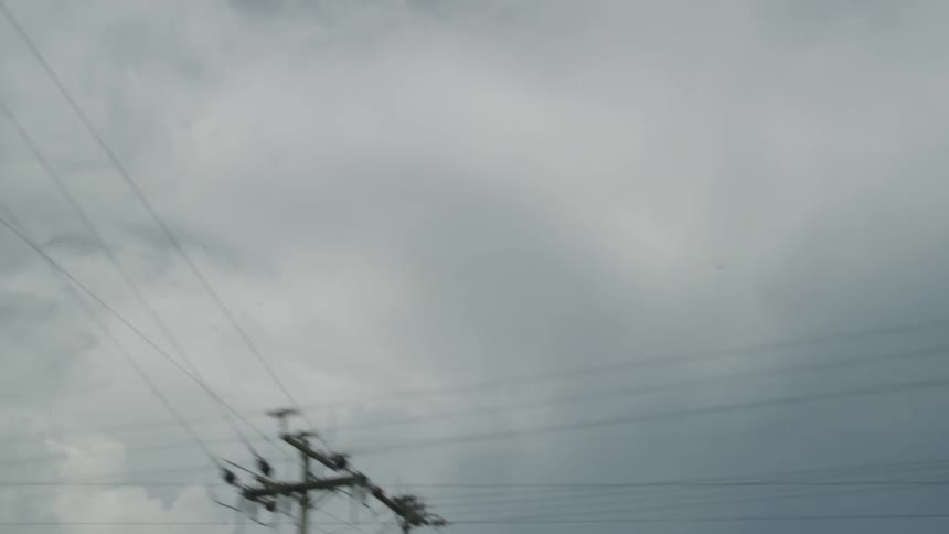 Clouds float over power lines
