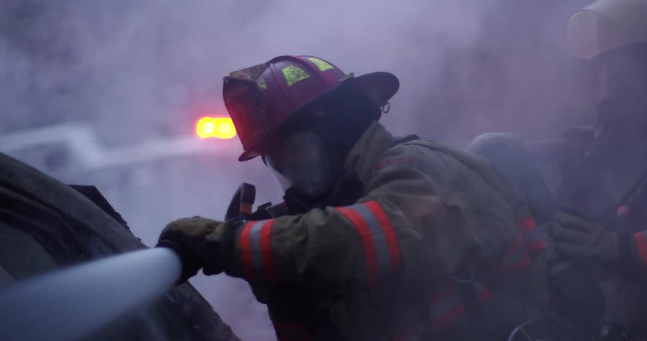 Firefighters extinguish a fire on a car