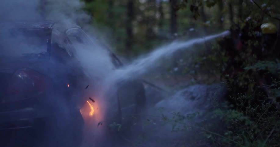 A car is on fire and firefighters are responding to the scene