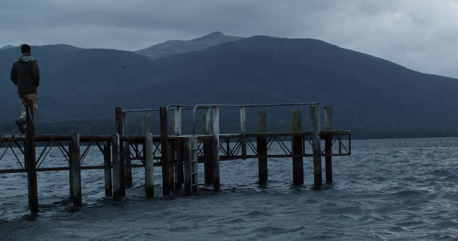 A man walks to the end of a dock
