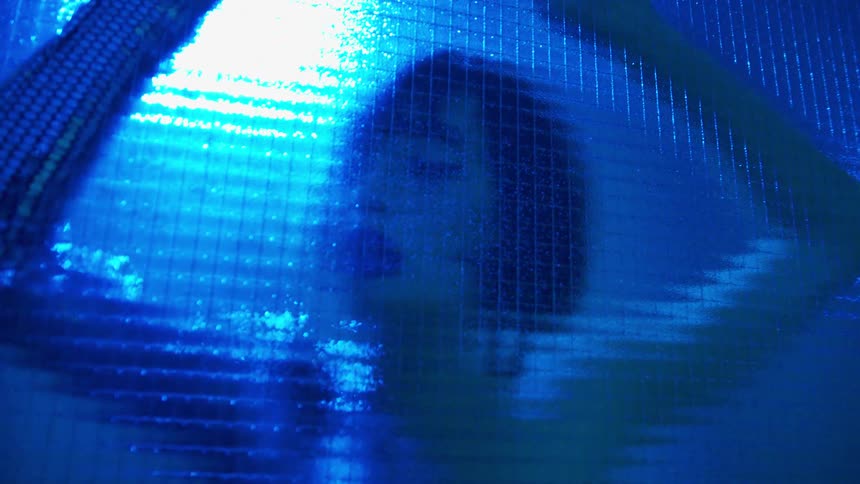 A dancer presses her body up against glass