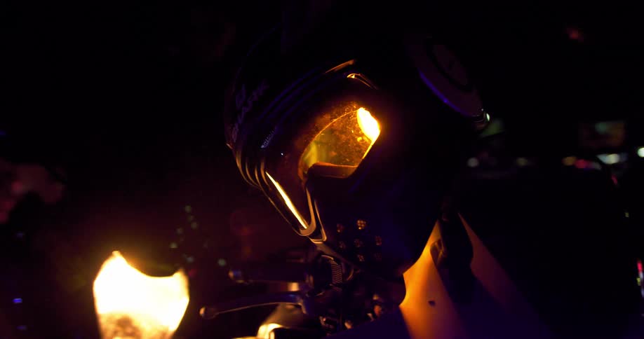 A helmet sits hanging over a motorcycles flashing light