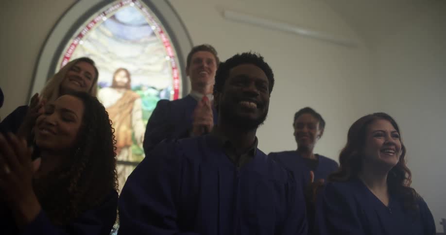 A church choir claps and sings in a church