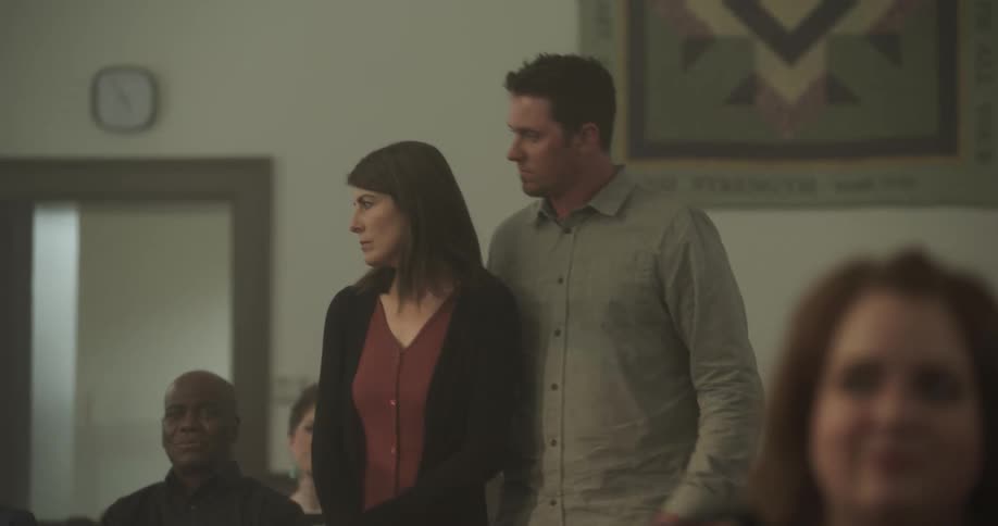Sad couple walking into church and sitting down on pew