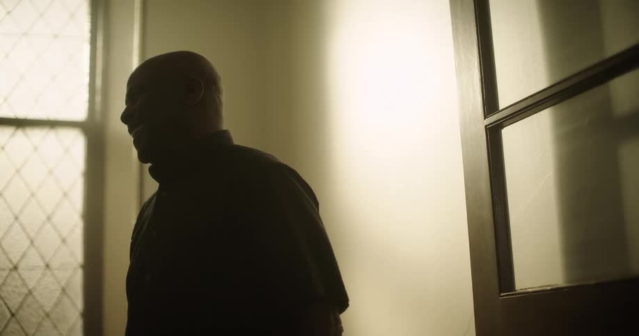 Man stands near open door laughing and talking