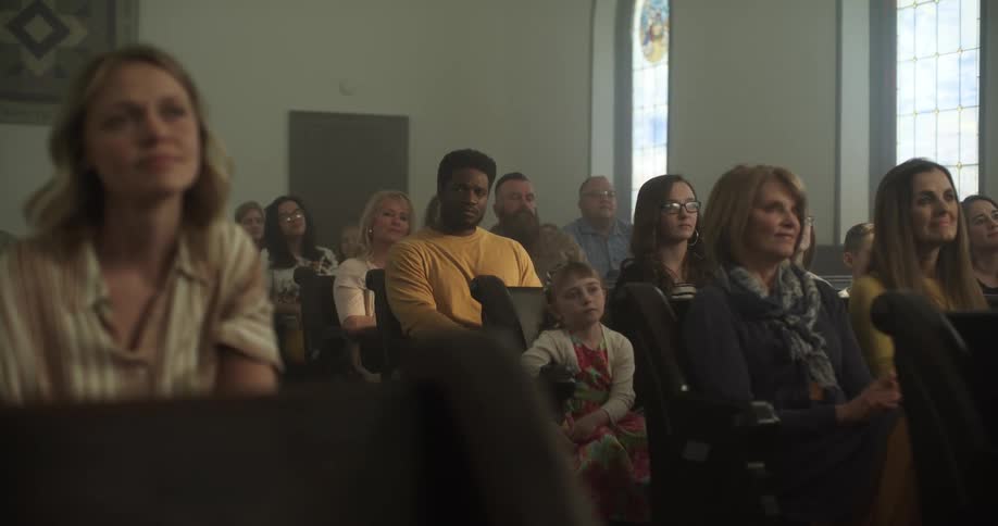A group of people sit in church pews
